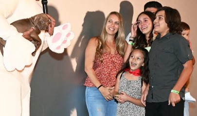 Actor Jean Carmelo De Grazia gives a gift to a family during the screening of his recent film